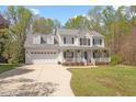Two-story traditional home with attached two-car garage and inviting front porch with white railing at 53 Stafford Cir, Clayton, NC 27527