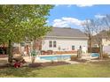 Backyard showcasing an in-ground pool, a grassy yard, and the rear exterior of the home at 5720 All Clear Ln, Wendell, NC 27591