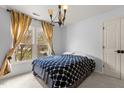 Cozy bedroom featuring a large window with natural light, complemented by a stylish chandelier and comfortable bed at 6209 Remington Lake Dr, Raleigh, NC 27616