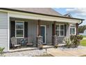 Charming front porch area with stone pillars, seating, and lovely landscaping details at 676 Wall Rd, Wendell, NC 27591