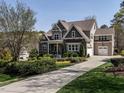 A large 2 story home with a 3-car garage, stone and siding exterior and nicely landscaped front yard at 7312 Ridgeline Dr, Raleigh, NC 27613