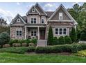 Charming two-story home with stone accents, manicured landscaping, and inviting front porch at 7312 Ridgeline Dr, Raleigh, NC 27613