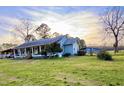 Side view of the home with a spacious yard and covered parking, offering great outdoor space at 8211 Julian Rd, Dunn, NC 28334