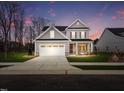 Charming two-story home with covered porch, two-car garage, and well-manicured lawn at dusk at 920 Jasper Mine Trl, Raleigh, NC 27610
