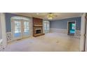 Open living room featuring a brick fireplace and direct access to the outdoor deck at 98 Lochridge Dr, Roxboro, NC 27573