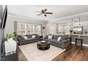 Bright living room features hardwood floors, neutral paint, and open layout to kitchen and dining area at 104 Chaseford Ct, Holly Springs, NC 27540