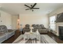 Cozy living room featuring a ceiling fan and view of the fireplace at 1102 Dartmouth Dr, Mebane, NC 27302