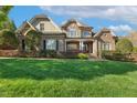 Elegant two-story brick and stone home with lush lawn and mature landscaping at 121 Highclere Ln, Cary, NC 27518
