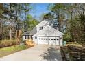 Home featuring an attached garage and a charming wooden deck with lush trees in the surrounding landscape at 124 Ripley Ct, Cary, NC 27513