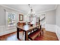 Charming dining room with hardwood floors, wainscoting, crown molding, and a rustic table at 1308 Helmsdale Dr, Cary, NC 27511