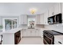 Bright kitchen with white cabinets, granite countertops, stainless steel appliances, and modern fixtures at 1308 Helmsdale Dr, Cary, NC 27511