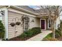 Inviting front entrance with meticulous landscaping and a decorative trellis with flowers at 1404 Palmer Hill Dr, Durham, NC 27703