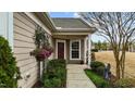 Close-up of a welcoming front porch with flowering plants and a neutral color palette at 1404 Palmer Hill Dr, Durham, NC 27703