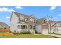 Charming two-story home with a covered porch, stone accents, and well-maintained landscaping, offering great curb appeal at 1415 Dalton Pl, Mebane, NC 27302