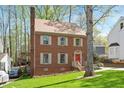 Attractive brick house surrounded by mature trees and lush greenery at 202 Lighthouse Way, Cary, NC 27511