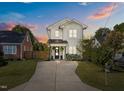 Beautifully landscaped home with a welcoming driveway, lush lawn, and craftsman architectural details at 207 Grand Ave, Raleigh, NC 27606