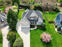 Aerial view of a well-manicured lawn surrounding a two-story home with a stone facade and a convenient three-car garage at 213 Billingrath Turn Ln, Cary, NC 27519