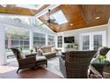 Bright sunroom with wood ceiling, skylights, multiple windows, and comfortable seating creating a relaxing indoor oasis at 213 Billingrath Turn Ln, Cary, NC 27519