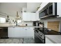 Well-lit kitchen featuring white cabinets, stainless steel appliances, and modern fixtures at 2133 Persimmon Ridge Dr, Raleigh, NC 27604