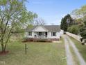 Aerial view of a well-kept home, detached garage, gravel driveway and serene surroundings at 221 Walkers Way, Willow Springs, NC 27592