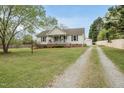 Traditional home boasting a gravel driveway, detached garage, well-maintained lawn and inviting curb appeal at 221 Walkers Way, Willow Springs, NC 27592