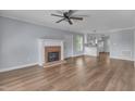 Inviting living room featuring a brick fireplace, ceiling fan and luxury vinyl flooring at 2306 Stafford Ave # A, Raleigh, NC 27607