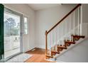Bright foyer featuring hardwood floors, staircase with wooden handrail, and a glass front door at 236 Summer Place Ct, Clayton, NC 27527