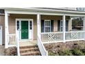 Inviting front porch with white railings, brick steps, and a vibrant green front door at 236 Summer Place Ct, Clayton, NC 27527