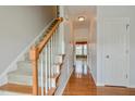 Hallway with wood floors, carpeted stairs, and neutral walls leading to multiple rooms at 236 Summer Place Ct, Clayton, NC 27527