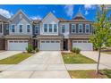 Charming townhome boasts a stone-accented facade, a one-car garage, and well-maintained landscaping at 242 Luftee Ln, Holly Springs, NC 27540