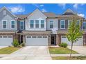 Charming townhome boasts a stone-accented facade, a one-car garage, and well-maintained landscaping at 242 Luftee Ln, Holly Springs, NC 27540