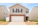 Charming two-story home with a two car garage, brick accents, manicured lawn, and a beautiful flower bed at 2512 Lily Dr, Haw River, NC 27258