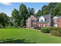 Attractive brick home with a well-maintained lawn, mature trees, and classic architectural details at 2514 Mcgowan Ct, Wake Forest, NC 27587