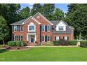 Charming two-story brick home with a lush green lawn, black shutters, and a welcoming front porch at 2514 Mcgowan Ct, Wake Forest, NC 27587