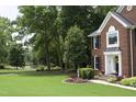 Charming brick home with lush landscaping, a well-manicured lawn, and inviting front porch, creating curb appeal at 2514 Mcgowan Ct, Wake Forest, NC 27587