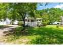 Lovely one-story home with a welcoming front porch, surrounded by mature trees and a well-maintained lawn at 2616 Bullock Rd, Durham, NC 27704