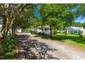 Quaint one-story home with a covered front porch, nestled among mature trees and a gravel driveway at 2616 Bullock Rd, Durham, NC 27704