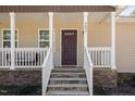 Inviting front porch featuring stone accents, white railing and a covered entryway at 297 Lane Store Rd, Franklinton, NC 27525