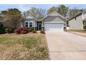 Charming home with gray siding, stone accents, and lush landscaping with blooming flowers at 3037 Willow Ranch Dr, Fuquay Varina, NC 27526