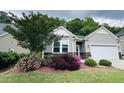Charming home with gray siding, stone accents, and lush landscaping with blooming flowers at 3037 Willow Ranch Dr, Fuquay Varina, NC 27526