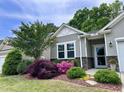 Charming home with gray siding, stone accents, and lush landscaping with blooming flowers at 3037 Willow Ranch Dr, Fuquay Varina, NC 27526
