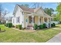 This home showcases a manicured lawn and charming architecture with a inviting front porch at 309 W Parrish Dr, Benson, NC 27504