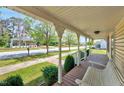 Inviting porch with ornate railings and a seating swing, overlooking a charming neighborhood street at 309 W Parrish Dr, Benson, NC 27504
