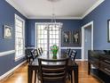 Dining room featuring a large window, hardwood flooring, and modern chandelier at 3100 Anderson Dr, Raleigh, NC 27609