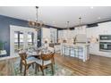 Cozy dining room adjacent to kitchen with wood table, modern chandelier, and access to the outdoors at 332 Tumbling River Dr, Wendell, NC 27591