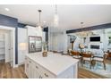 Open-concept kitchen boasts white cabinetry, stainless appliances, island seating, and seamless flow to living areas at 332 Tumbling River Dr, Wendell, NC 27591