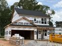 New construction home featuring a two-car garage awaiting finishing touches in a wooded community at 35 Fetterbush Way, Clayton, NC 27520