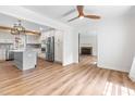 Bright, open-concept kitchen featuring an island, stainless appliances, and modern finishes adjacent to an empty living room at 4012 Old Sturbridge Dr, Apex, NC 27539