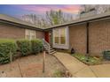 Charming brick home featuring a red front door, concrete walkway, and landscaped yard at 4705 Matt Dr # B, Raleigh, NC 27604