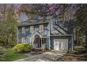 Charming two-story home featuring a well-manicured lawn and attached garage, painted in light blue at 4725 Sinclair Dr, Raleigh, NC 27616